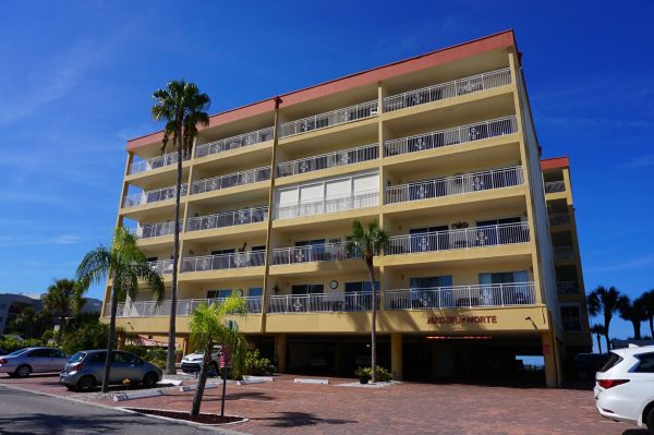 Tall multi-story beachfront condo building featuring spacious private balconies.