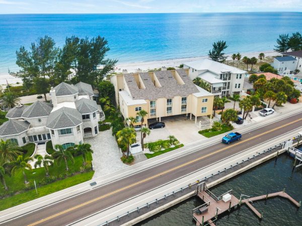 Aerial view of a two-story residential condo property surrounded by lush green trees.