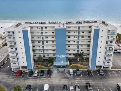 Front exterior view of a multi-story white resort building under a clear sky.