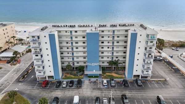 Front exterior view of a multi-story white resort building under a clear sky.