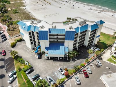 An aerial photograph of a blue multi-story resort building near the beach.